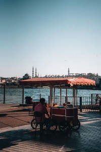 水边小贩与远处清真寺的宁静午后