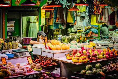 色彩斑斓的水果摊主专注称重