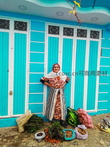 蓝墙前摊主微笑展示自家农产品