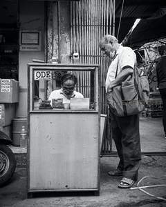 黑白街景中老人排队办理业务