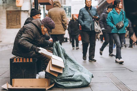 街头拾荒者专注整理纸箱