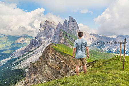 阿尔卑斯草甸，徒步者仰望雄伟山峰