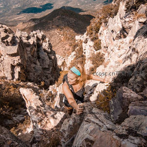 女子攀岩于险峻山崖之上