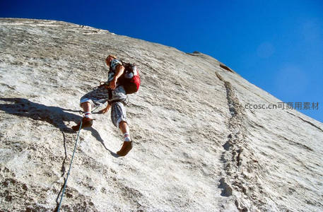 仰拍视角下的攀岩者征服巨岩