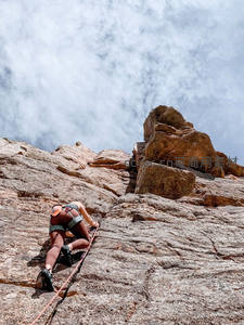 仰视视角下的女性攀岩者挑战高峰