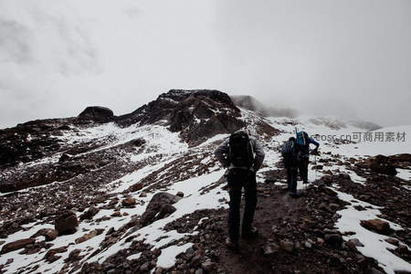徒步者穿越雪山碎石小径