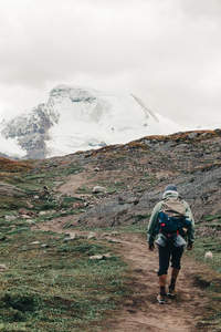 独自踏上高原小径，身后是静默的雪山