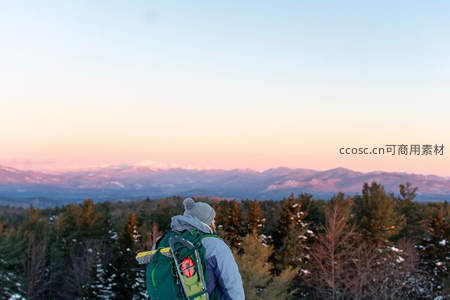 背包客山顶远眺日落雪山美景