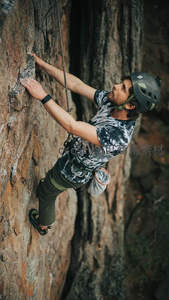 专注攀岩者紧握岩点，征服垂直世界