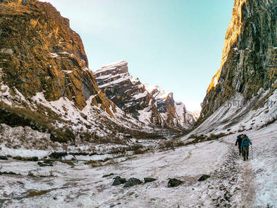 雪谷中的徒步者向着远山进发