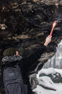 雪地岩壁下举火把的探险者