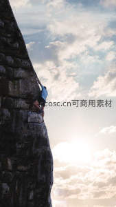 攀岩者挑战陡峭岩壁迎朝阳