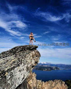 情侣在悬崖之巅拥抱俯瞰峡湾美景