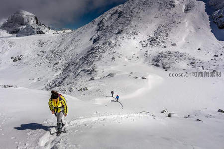 雪地徒步者穿越崎岖高山雪原