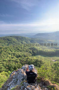 骑行者山顶俯瞰翠绿山谷风光