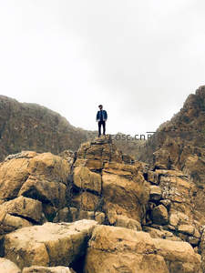 孤身立于险峰之巅，俯瞰苍茫山河