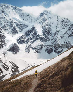黄衣行者独步雪谷，远眺巍峨雪山