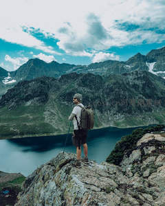 山巅旅人远眺湖泊与群峰