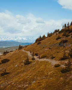 山脊小径上徒步者远眺雪峰