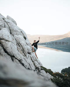 攀岩者在峭壁上做出胜利手势