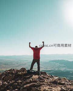 登顶成功男子高举双臂庆祝胜利