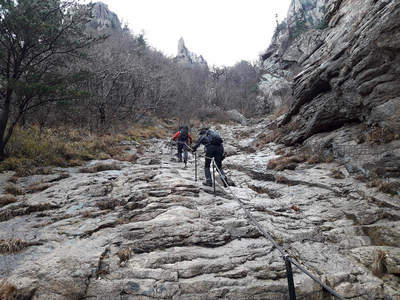 登山者沿着崎岖石径向山峰进发