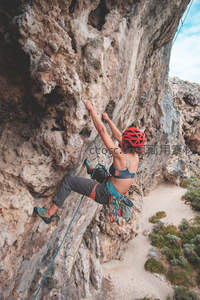 岩壁飞舞，女攀岩者专注登顶瞬间