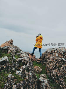 雨衣旅人，岩石间专注记录山野风景