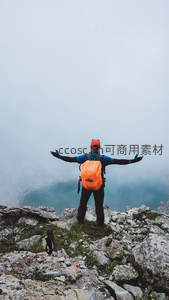 登山者张开双臂拥抱云雾缭绕山巅