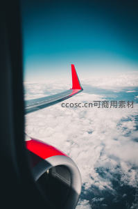 舷窗外的蓝天白云与红色机翼