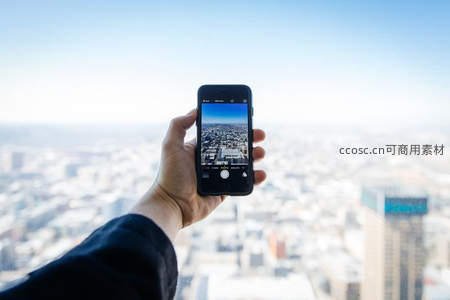 手持手机俯瞰城市全景记录瞬间