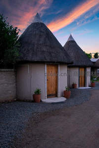 茅草圆顶小屋在晚霞中静谧安详