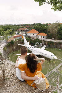 情侣依偎俯瞰悬崖边飞机雕塑