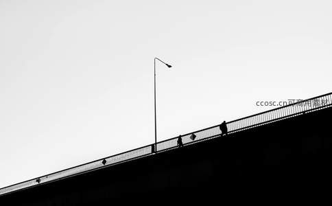 桥上剪影行人与孤灯