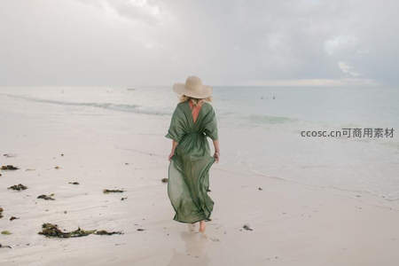 绿裙女子海边漫步