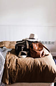 床铺上的旅行包与帽子静物特写