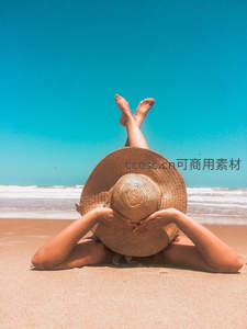 沙滩上的草帽女孩，背对碧海蓝天享受假期