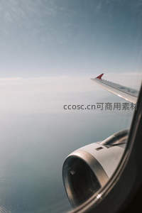 舷窗外的飞行视角，机翼划过云层俯瞰大地