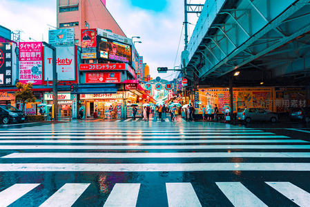 雨后街景霓虹闪，行人撑伞过斑马