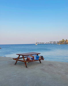 海边长椅上酣睡的度假者