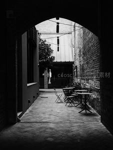 黑白影像中拱门下静谧的户外咖啡座