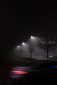 雾夜街灯下，车影匆匆如流光
