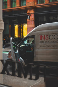 城市街角的工程车与时尚店铺