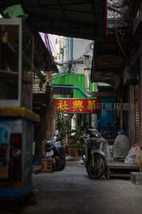 老城区巷弄深处，摩托车与招牌