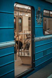 蓝色地铁车厢门开启，乘客静坐内部