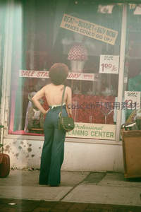 复古橱窗前凝望的时尚女子背影