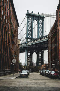 曼哈顿大桥钢铁巨构横跨在红砖巷弄间