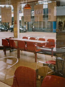 透过玻璃窗看街景，红色座椅映衬城市日常