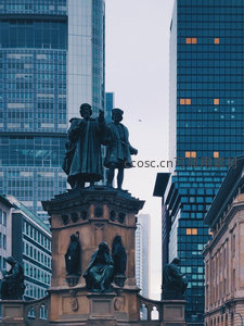 现代摩天楼间的古典雕像广场