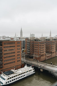 雾中港口城市风光，红砖建筑与游船相映成趣